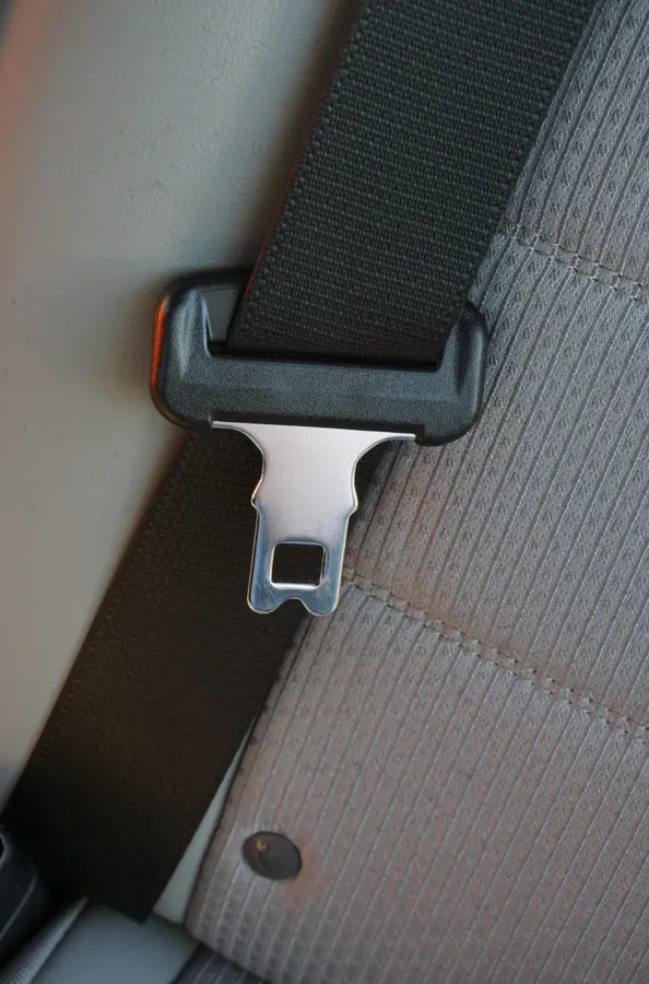 Seat belt latch plate and mounting detail at a vehicle seating position