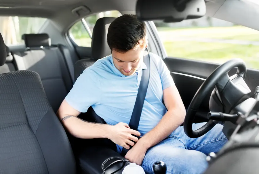 Driver seated in a car with the seat belt across the chest