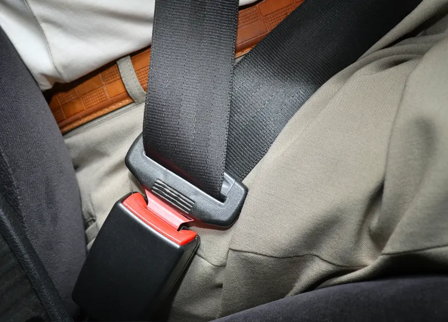 Lap section of a fastened seat belt across an occupant