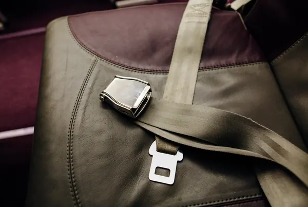 Metal lap belt buckle on an upholstered seat